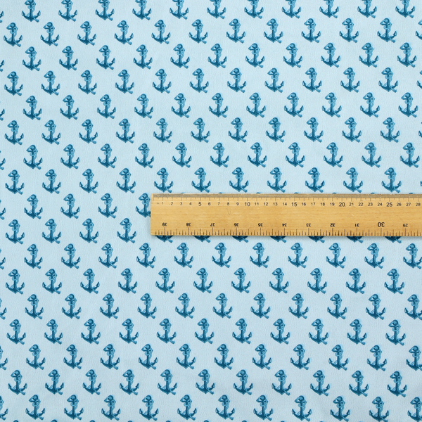 A nautical-themed fabric pattern featuring a repeating print of dark blue anchors against a light blue background.