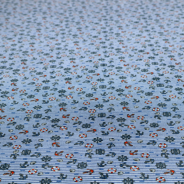 The pattern features a nautical theme filled with tiny ships' steering wheels, anchors, and lifebuoys scattered across the fabric.