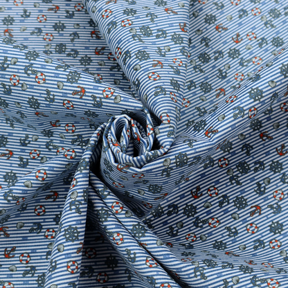 The pattern features a nautical theme filled with tiny ships' steering wheels, anchors, and lifebuoys scattered across the fabric.