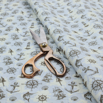 The pattern features a nautical-themed collage consisting of lighthouses, sailing ships, anchors, compasses, compass roses, seashells, ship bells, and marlin fish.
