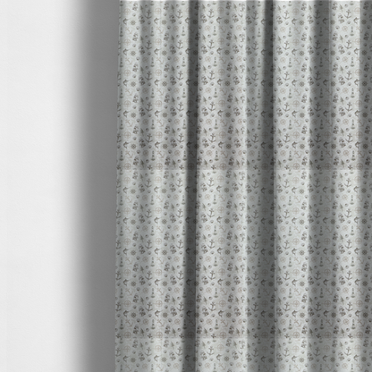The fabric used to create these made-to-measure curtains is a pattern features a nautical-themed collage containing lighthouses, sailing ships, anchors, compass roses, seashells, steering wheels, ship bells, and marlin fish.