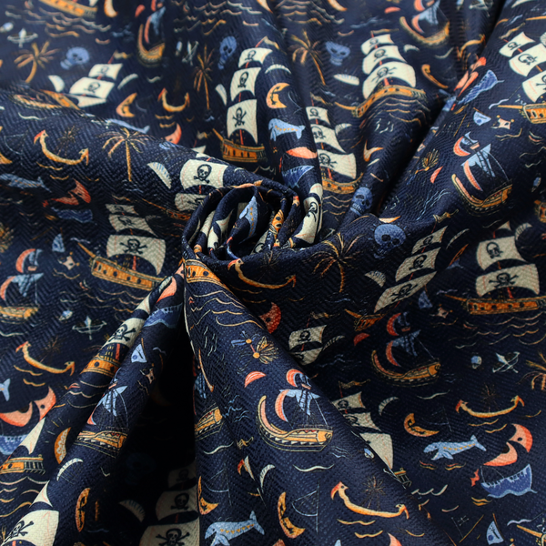 A dark navy blue fabric patterned with a repeating pirate-themed design featuring multi-sailed galleon ships with skull-and-crossbones flags sailing on stylized waves, accompanied by smaller elements including blue whales, crescent moons, skulls, tropical palm trees, and anchors.
