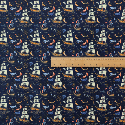A dark navy blue fabric patterned with a repeating pirate-themed design featuring multi-sailed galleon ships with skull-and-crossbones flags sailing on stylized waves, accompanied by smaller elements including blue whales, crescent moons, skulls, tropical palm trees, and anchors.