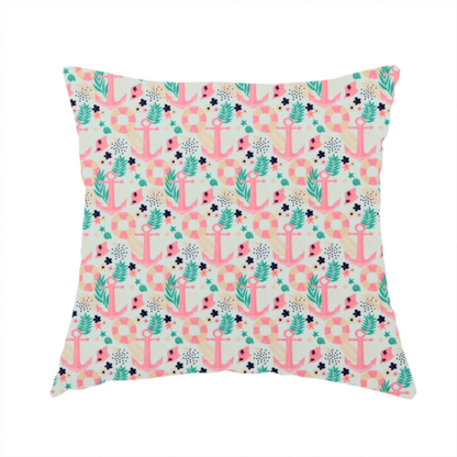 The fabric used to create this handmade cushion is a light mint green fabric with a repeating nautical pattern featuring pink anchors framed by teal palm fronds, interspersed with pink and white striped life rings, tiny dark blue flowers, and small coral shells.