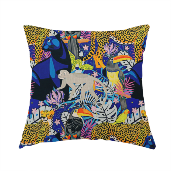 The fabric used to create this handmade cushion is a vibrant jungle-themed fabric on a rich blue background featuring a repeating pattern of yellow leopards with black spots, blue panthers, toucans with bright orange and yellow beaks, light grey monkeys, small yellow-and-red birds, and lush tropical leaves and pink flowers.