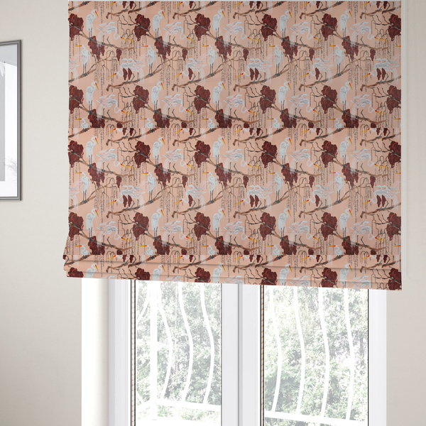 The fabric used to create these Roman blinds is a peach-pink fabric with an illustrated botanical and avian pattern featuring white egrets perched on brown branches among dark red, stylized foliage and weeping floral tendrils.