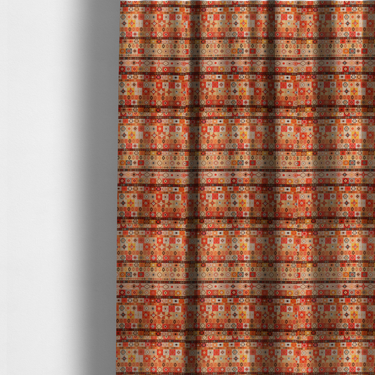 The fabric used to create these made-to-measure curtains is a geometric woven fabric featuring horizontal rows of Aztec and tribal-inspired patterns in warm earthy tones of orange, red, yellow, beige, brown, and dark charcoal.