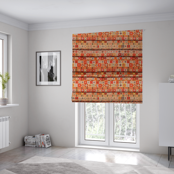 The fabric used to create these Roman blinds is a geometric woven fabric featuring horizontal rows of Aztec and tribal-inspired patterns in warm earthy tones of orange, red, yellow, beige, brown, and dark charcoal.