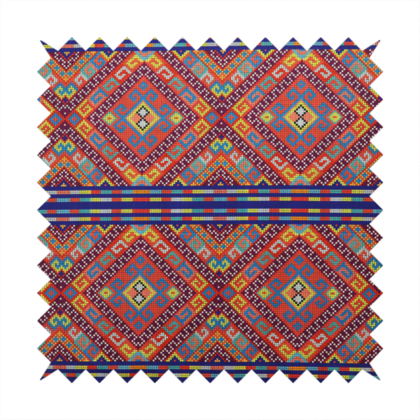 A vibrant geometric fabric featuring a detailed pixelated pattern of large interlocking diamonds in red, blue, purple, yellow, and turquoise, separated by horizontal striped bands of multi-coloured dots on a dark blue background, reminiscent of traditional beadwork or woven textile art.