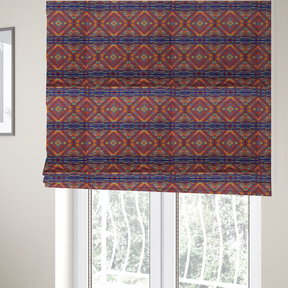 The fabric used to create these Roman blinds is a vibrant geometric fabric featuring a detailed pixelated pattern of large interlocking diamonds in red, blue, purple, yellow, and turquoise, separated by horizontal striped bands of multi-coloured dots on a dark blue background, reminiscent of traditional beadwork or woven textile art.