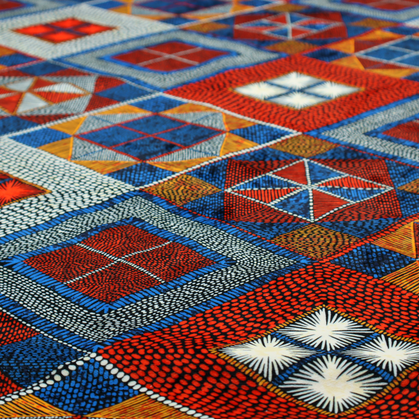 A geometric African wax print fabric featuring an intricate repeating pattern of nested diamonds, squares, and triangular motifs.