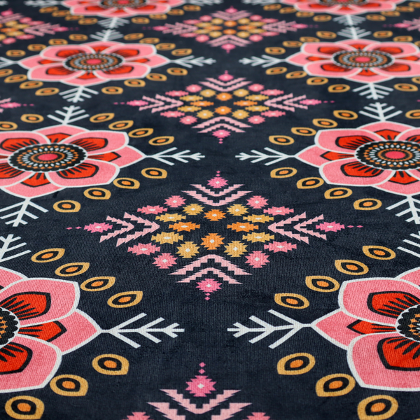 A repeating folk-art textile design featuring alternating rows of stylized pink floral blossoms and intricate diamond-shaped geometric motifs.