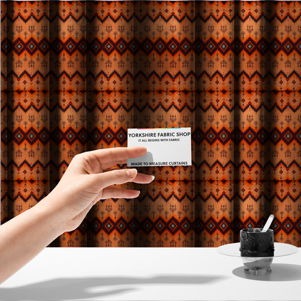 The fabric used to create these made-to-measure curtains is a Aztec-inspired tribal ikat fabric featuring horizontal bands of sharp zigzags and diamond motifs.