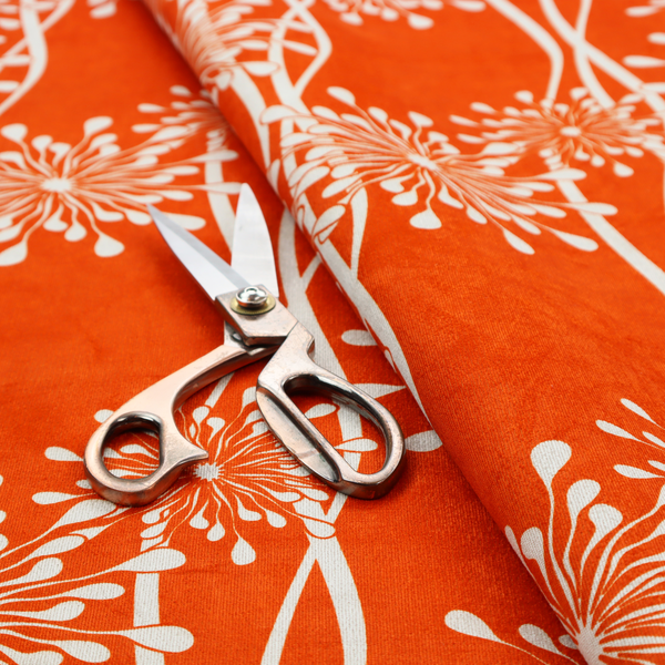 A modern botanical fabric featuring abstract, starburst floral or dandelion motifs paired with vertical wavy lines.