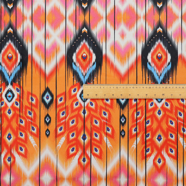A vibrant orange fabric featuring a bold Southwestern Aztec and ikat-style geometric pattern.