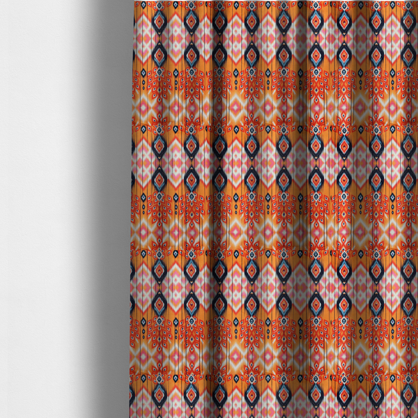 The fabric used to create these made-to-measure curtains is a vibrant orange fabric featuring a bold Southwestern Aztec and ikat-style geometric pattern.