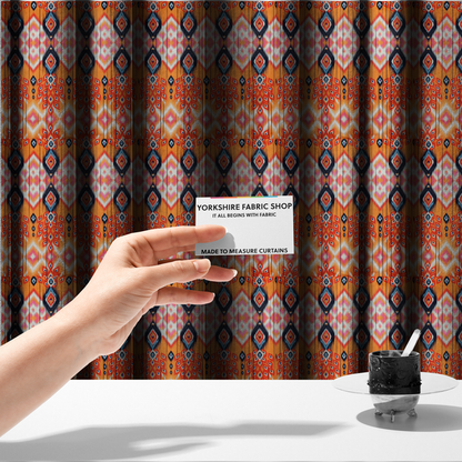 The fabric used to create these made-to-measure curtains is a vibrant orange fabric featuring a bold Southwestern Aztec and ikat-style geometric pattern.