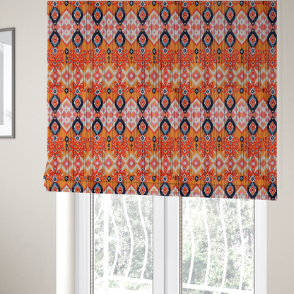 The fabric used to create these Roman blinds is a vibrant orange fabric featuring a bold Southwestern Aztec and ikat-style geometric pattern.