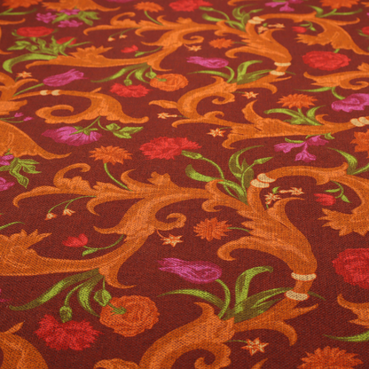 A repeating pattern of ornate, golden-orange baroque scrolls and acanthus leaves intermixed with detailed botanical elements including red roses, magenta tulips, and green foliage, all set against a deep crimson red background.