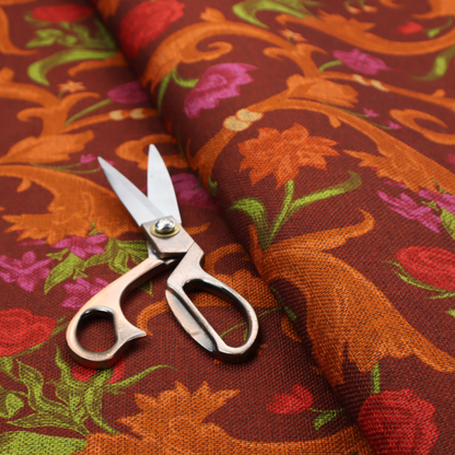 A repeating pattern of ornate, golden-orange baroque scrolls and acanthus leaves intermixed with detailed botanical elements including red roses, magenta tulips, and green foliage, all set against a deep crimson red background.