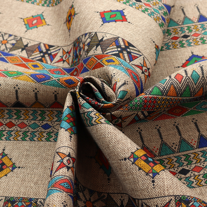 A multi-coloured ethnic geometric fabric with repeating rows of colourful tribal diamonds, zigzags, and striped borders set against a light neutral background.