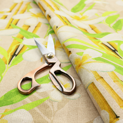 A tropical botanical fabric pattern with white plumeria blossoms featuring yellow centres, paired with green leaves and yellow bamboo stalks, set against a light beige background.