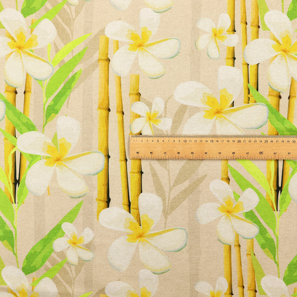 A tropical botanical fabric pattern with white plumeria blossoms featuring yellow centres, paired with green leaves and yellow bamboo stalks, set against a light beige background.