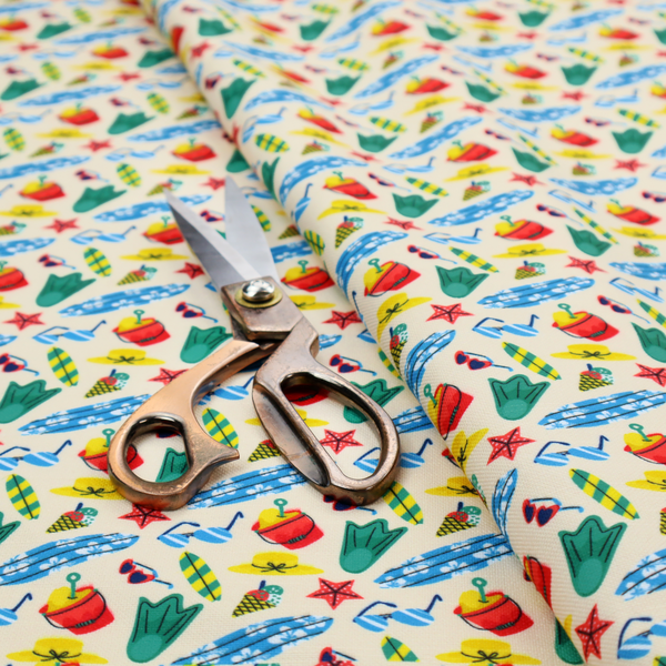 A vibrant, repeating beach-themed pattern on a light cream background, featuring small illustrations of blue and white surfboards, red buckets, green swim flippers, sunglasses, yellow sunhats, starfishes, and popsicles.