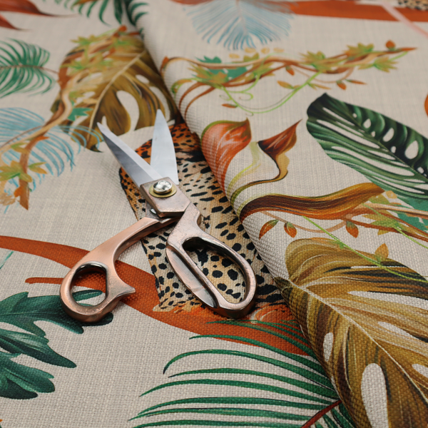 Fabric pattern featuring lounging leopards surrounded by vibrant tropical leaves, monstera fronds, and vines on a light-coloured background.