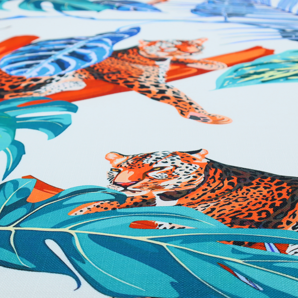 Pattern fabric featuring leopards resting on orange branches amidst vibrant blue and turquoise tropical leaves and foliage against a light background.