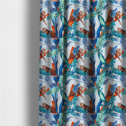 The fabric used to create these made-to-measure curtains has leopards resting on orange branches amidst vibrant blue and turquoise tropical leaves and foliage against a light background.