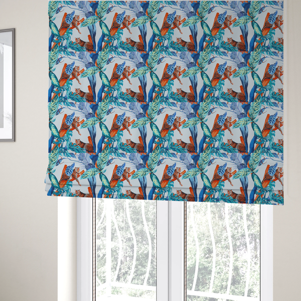 The fabric used to create these Roman blinds has leopards resting on orange branches amidst vibrant blue and turquoise tropical leaves and foliage against a light background.