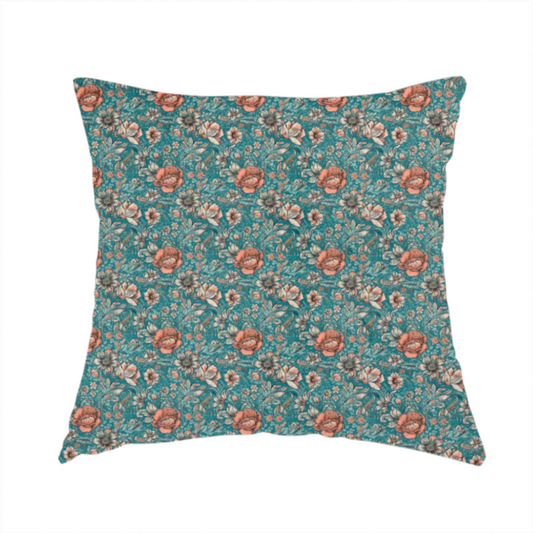 The fabric used to create this handmade cushion is a dense, vintage-style floral repeating pattern featuring peach and muted white flowers with detailed leaves and foliage against a vibrant teal background.