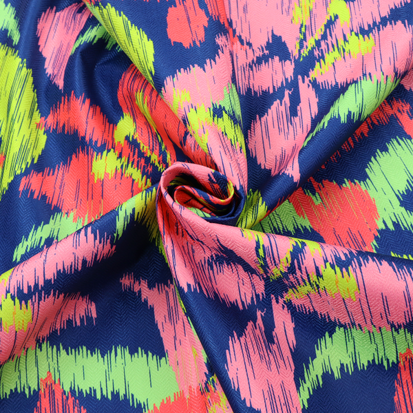 A vibrant fabric pattern featuring large coral and light pink lily flowers with bright lime green leaves against a solid royal blue background.