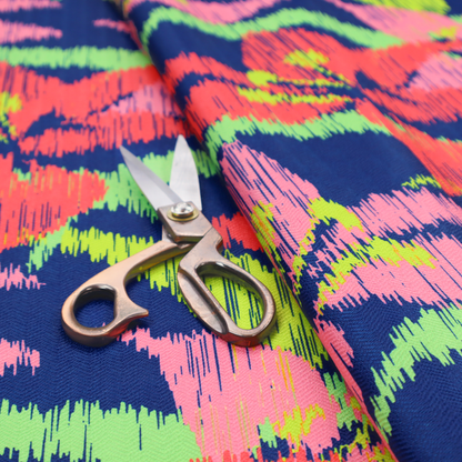 A vibrant fabric pattern featuring large coral and light pink lily flowers with bright lime green leaves against a solid royal blue background.
