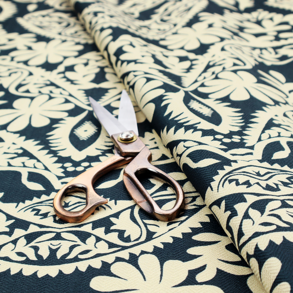 A dark midnight blue fabric featuring an ornate, repeating damask pattern in creamy off-white, composed of intricate scrollwork, floral motifs, and symmetrical ogee shapes.