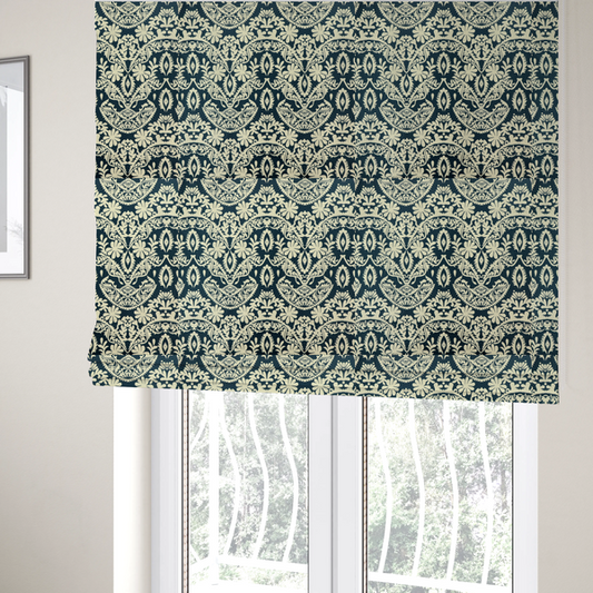 The fabric used to create these Roman blinds is a dark midnight blue fabric featuring an ornate, repeating damask pattern in creamy off-white, composed of intricate scrollwork, floral motifs, and symmetrical ogee shapes.