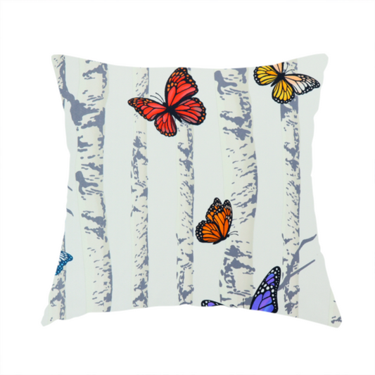 The fabric used to create this handmade cushion is a light-coloured fabric featuring a pattern of vertical grey and white birch tree trunks interspersed with colourful butterflies in shades of red, orange, yellow, blue, and purple.