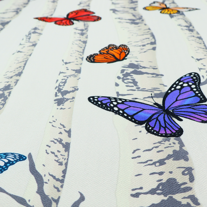A light-coloured fabric featuring a pattern of vertical grey and white birch tree trunks interspersed with colourful butterflies in shades of red, orange, yellow, blue, and purple.