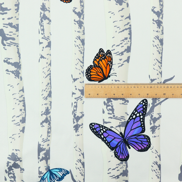 A light-coloured fabric featuring a pattern of vertical grey and white birch tree trunks interspersed with colourful butterflies in shades of red, orange, yellow, blue, and purple.