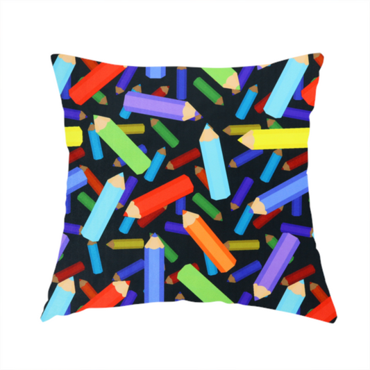 The fabric used to create this handmade cushion is a black fabric featuring a playful, repeating pattern of coloured pencils in various shades including red, yellow, light blue, green, purple, and orange scattered diagonally across the background.