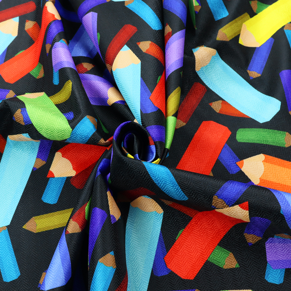 A black fabric featuring a playful, repeating pattern of coloured pencils in various shades including red, yellow, light blue, green, purple, and orange scattered diagonally across the background.