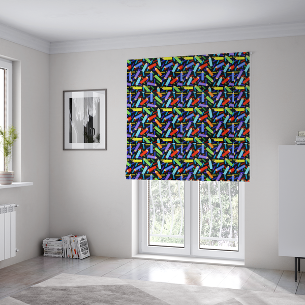 The fabric used to create these Roman blinds is a black fabric featuring a playful, repeating pattern of coloured pencils in various shades including red, yellow, light blue, green, purple, and orange scattered diagonally across the background.