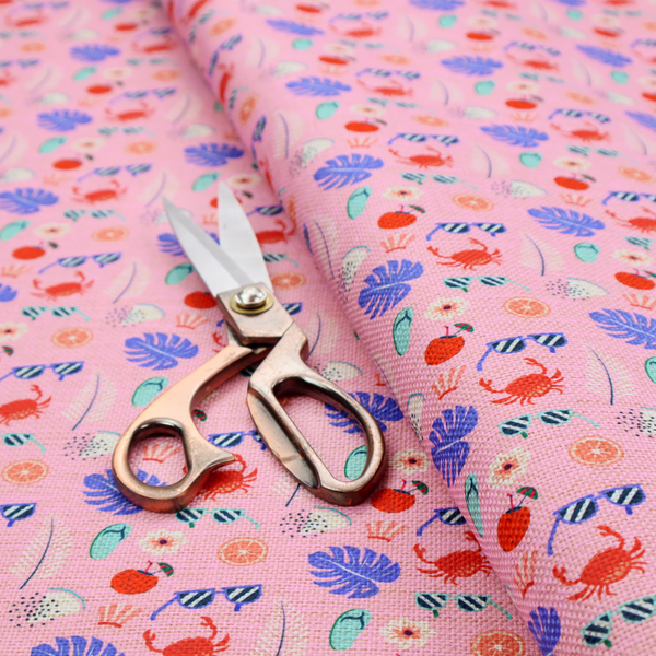 Pink summer-themed fabric featuring a repeating pattern of tropical icons including crabs, sunglasses, cherries, flip-flops, palm leaves, citrus slices, and flowers.
