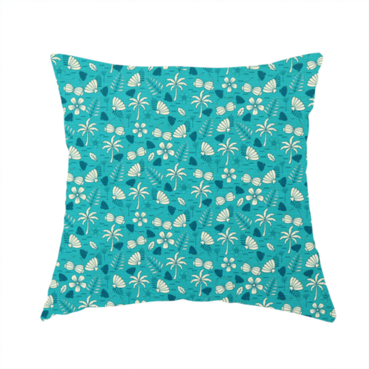 The fabric used to create this handmade cushion is a teal summer-themed fabric featuring a repeating pattern of palm trees, seashells, flowers, and tropical foliage.