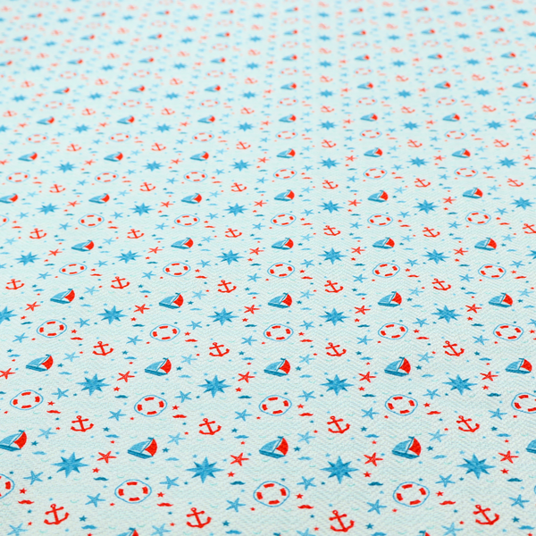 Light blue fabric featuring a small-scale repeating nautical pattern of red anchors, lifebuoys, and sailboats, interspersed with blue and red stars.