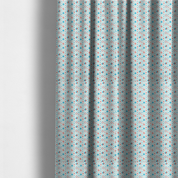 The fabric used to create these made-to-measure curtains is a light blue fabric featuring a small-scale repeating nautical pattern of red anchors, lifebuoys, and sailboats, interspersed with blue and red stars.