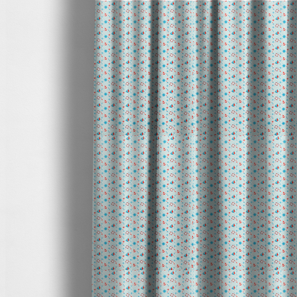 The fabric used to create these made-to-measure curtains is a light blue fabric featuring a small-scale repeating nautical pattern of red anchors, lifebuoys, and sailboats, interspersed with blue and red stars.