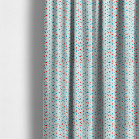 The fabric used to create these made-to-measure curtains is a light blue fabric featuring a small-scale repeating nautical pattern of red anchors, lifebuoys, and sailboats, interspersed with blue and red stars.