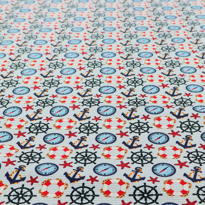 Light blue fabric with a dense repeating nautical pattern featuring dark blue anchors, black ship wheels, blue compasses, red-and-white lifebuoys, and tiny red stars.
